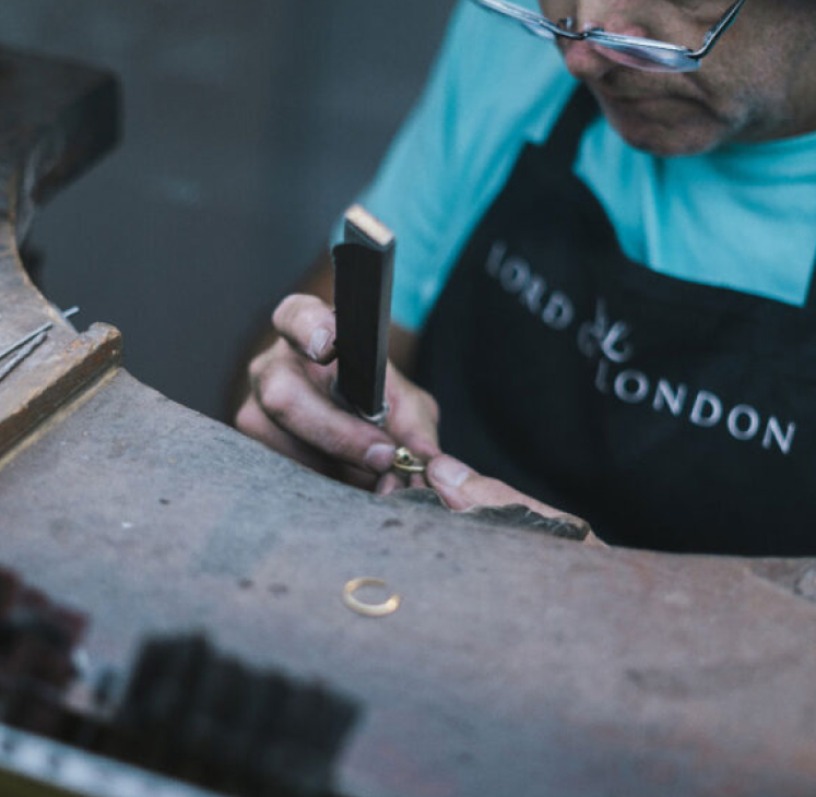 A man is working on a piece of jewelry.