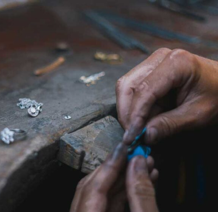 A person is working on a piece of jewelry.